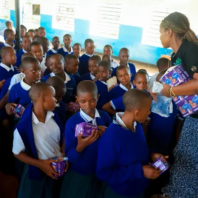 Packets of sanitary pads being handed out to students in the school hall at Kafundo Secondary School