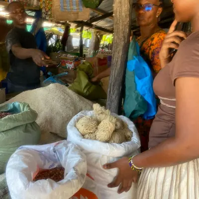 Volunteers buying sacks of grain at a market stall for Sintanaizer Foundation