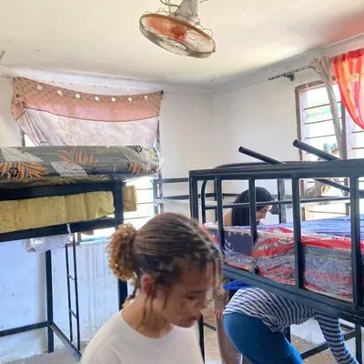 Volunteers assembling metal bunk beds in a dormitory at Sintanaizer Foundation